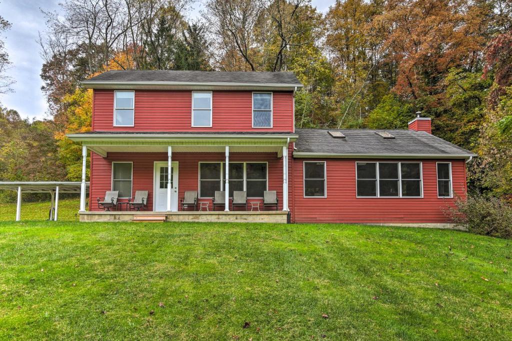 a red house on top of a green yard at Sugar Grove Escape with Hot Tub and Grill! in Sugar Grove