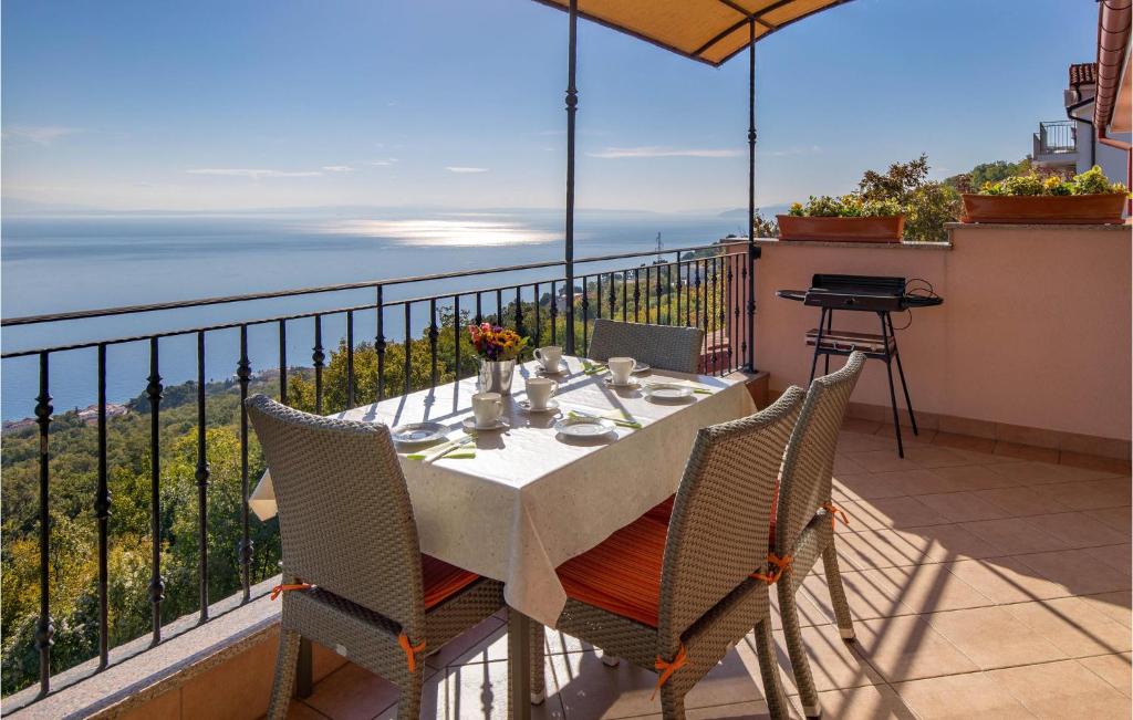 a table and chairs on a balcony with a view of the ocean at Awesome Apartment In Icici With House Sea View in Ičići