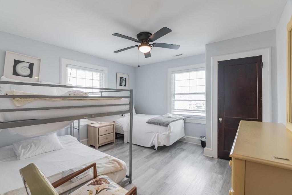 a bedroom with two bunk beds and a ceiling fan at Large Patio with Ocean Views Beach Block Parking Unit 3 in Ventnor City