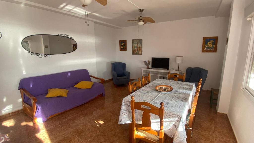 uma sala de estar com uma mesa e um sofá roxo em Apartamento en primera linea de mar. em Múrcia