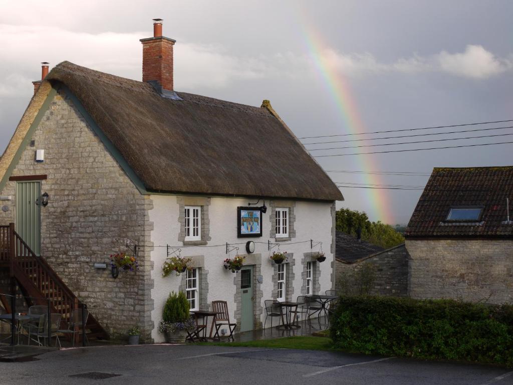 a house with a rainbow in the sky at The Kingsdon Inn in Kingsdon