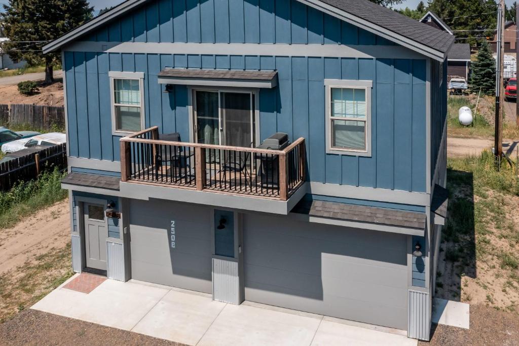 a blue house with a porch and a balcony at Tamarack Trails Bungalow in Donnelly