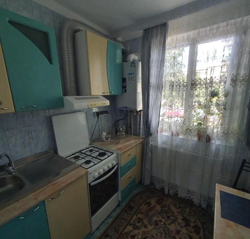 a small kitchen with a stove and a window at SWEET HOME & LiLiANA in Tecuci