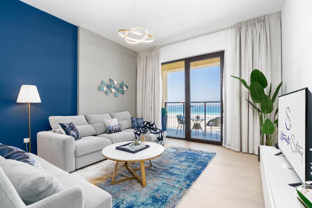 a living room with a couch and a table at Ultimate Stay / 4 People / Beachfront / Sea View / Balcony Sunset / Brand New / La Mer in Dubai