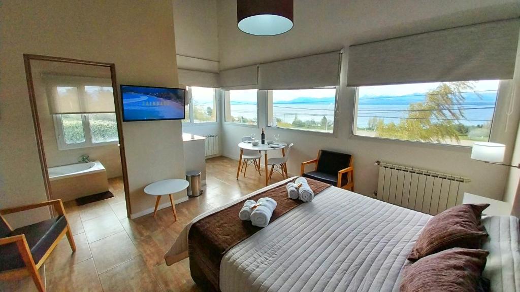 um quarto com uma cama grande e uma televisão em Las Victorias Suites Bariloche em San Carlos de Bariloche