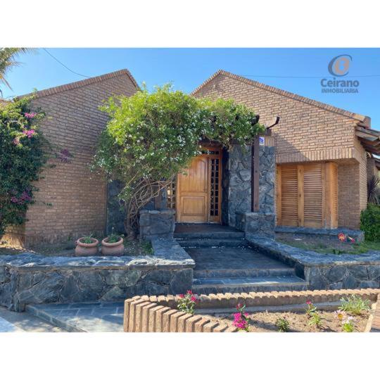 a brick house with a wooden door and some plants at Casa tradicional, amplia y funcional in San Francisco