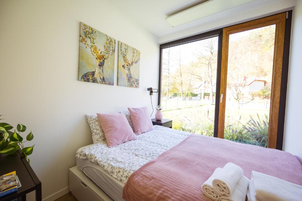 1 dormitorio con cama rosa y ventana en KaZielnik en Kazimierz Dolny