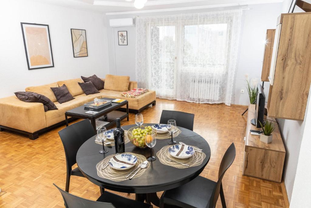a living room with a table and chairs and a couch at Apartman Tihana in Vinkovci