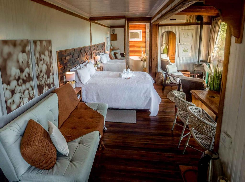 a large bedroom with a bed and a couch at IL Rifugio Cabanas in Urubici
