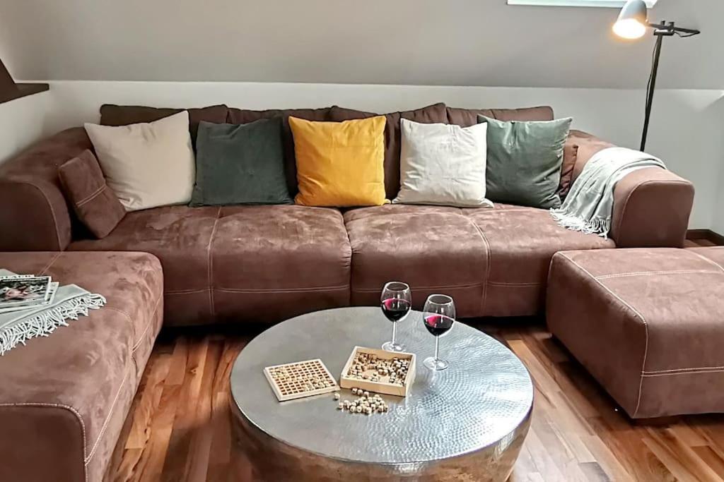 a living room with a couch and two glasses of wine at Fewo "Am Bienenstock" in Dallgow-Döberitz in Dallgow