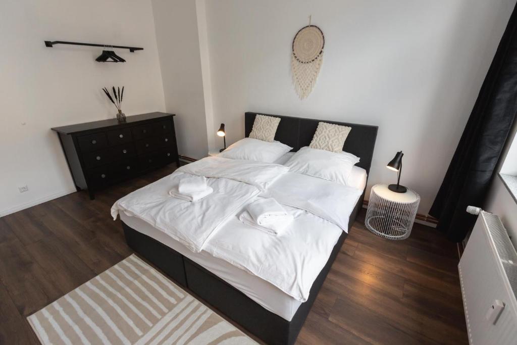 1 dormitorio con 1 cama grande con sábanas blancas en Koje Eins I Großes Apartment mit 2 Schlafzimmern, en Bremerhaven
