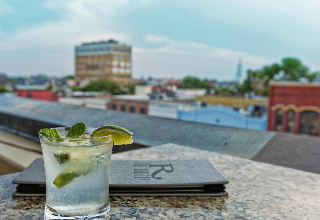 a drink on a table with a view of a city at The Vendue, Downtown Art Hotel in Charleston