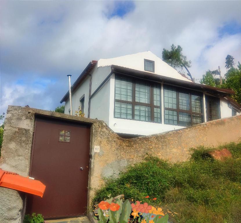 una casa con una valla y un garaje en Casinha da Sobreira en Penacova