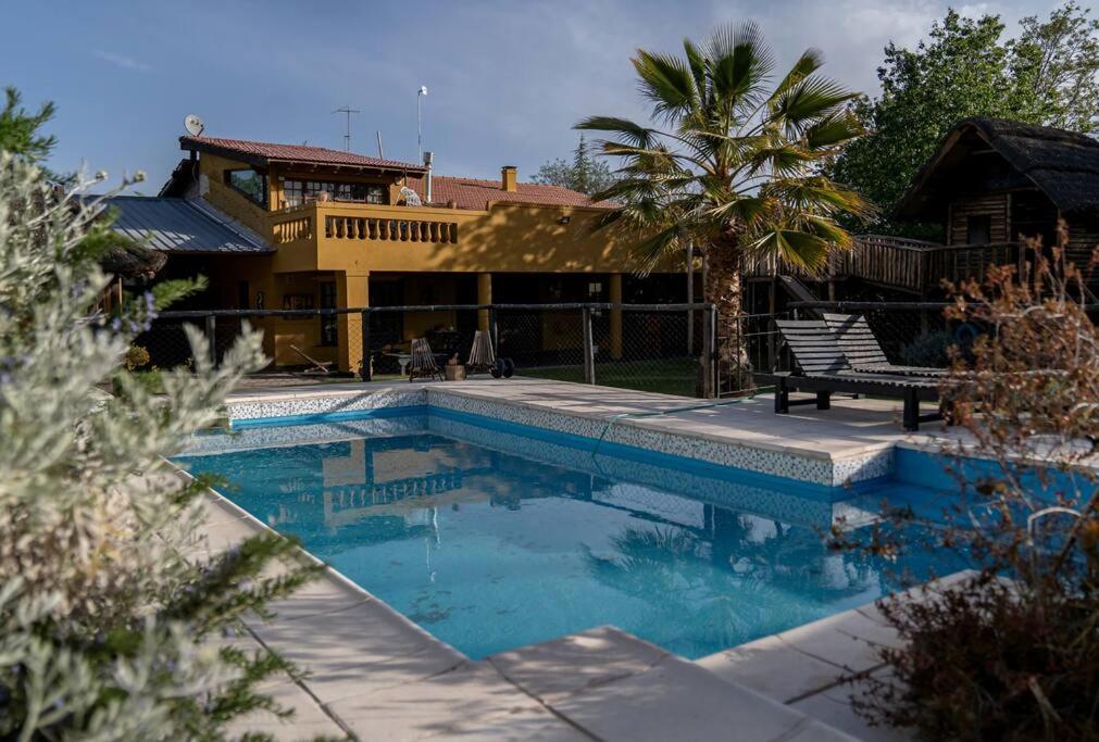a swimming pool in front of a house at Casona alegre con pileta y amplio jardin in Las Compuertas