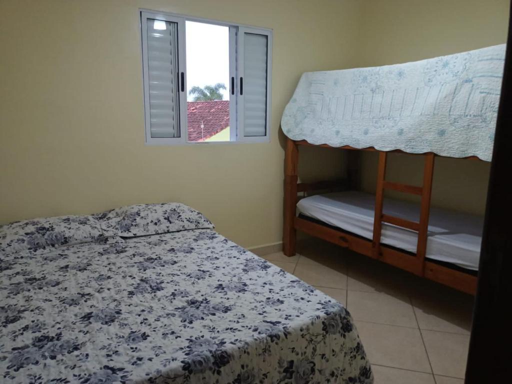 a bedroom with a bunk bed and a window at Lindo Sobrado in Mongaguá
