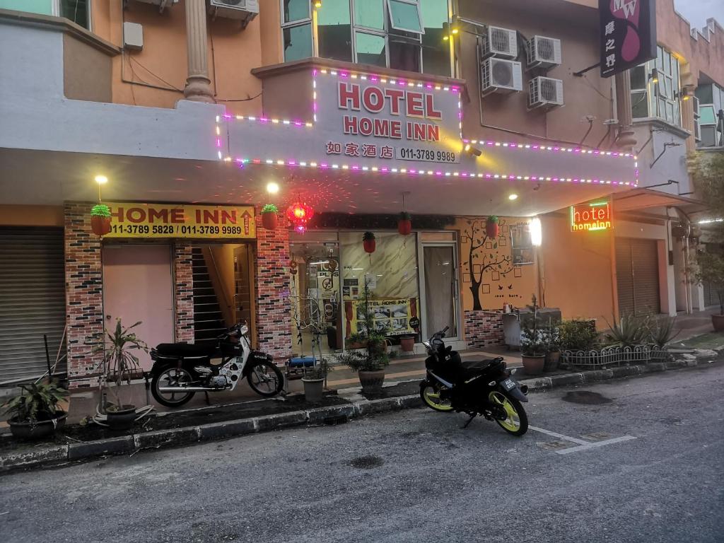 a hotel with two motorcycles parked in front of it at Home Inn Hotel in Ipoh