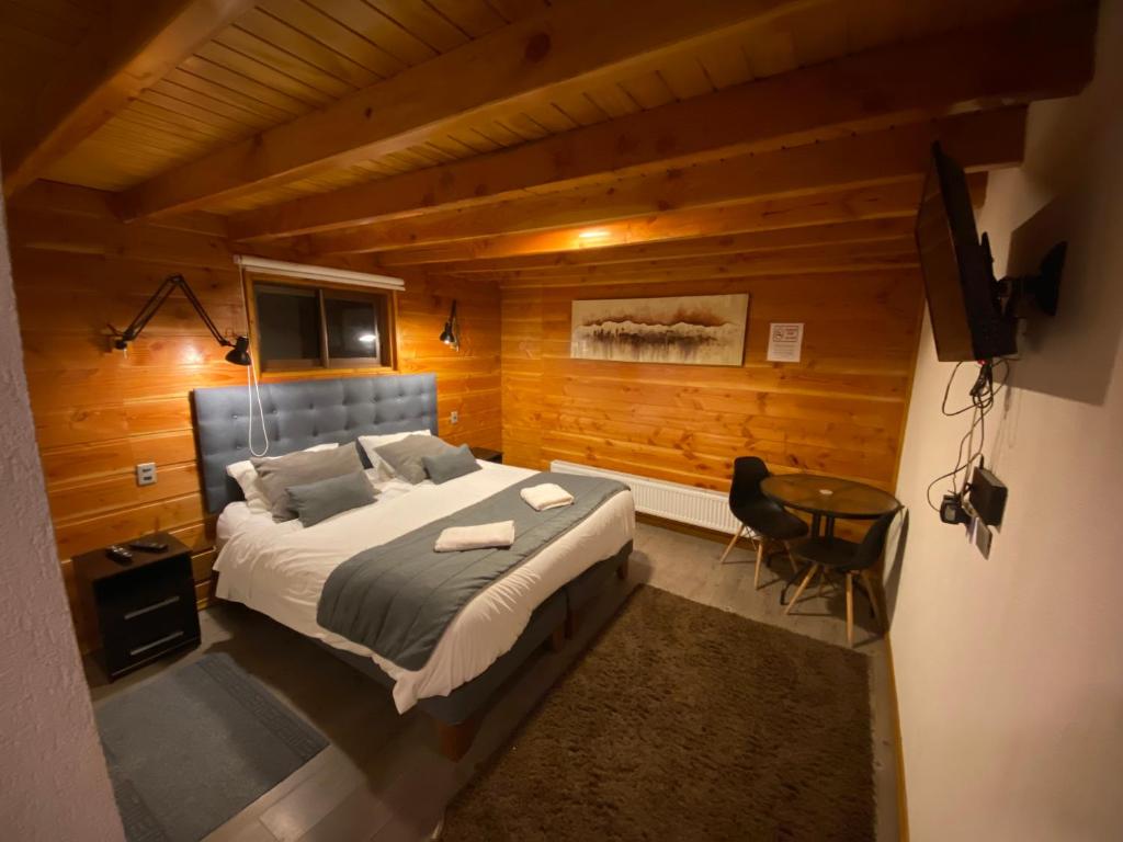 um quarto com uma cama grande e uma mesa em Hotel Andes Pucón em Pucón