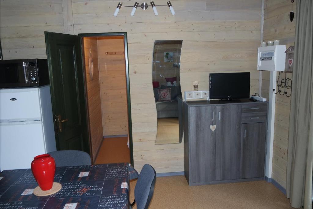a room with a kitchen with a table and a television at Chalet Hertzland in Ranspach