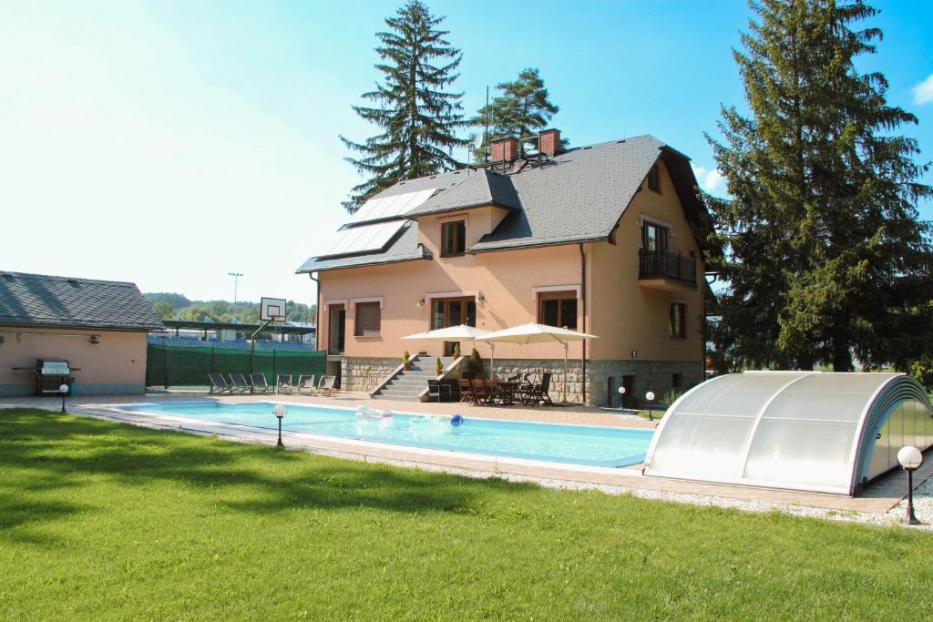a house with a swimming pool in front of a house at Villa for 20 people with Jacuzzi and Large Pool in Mikulovice