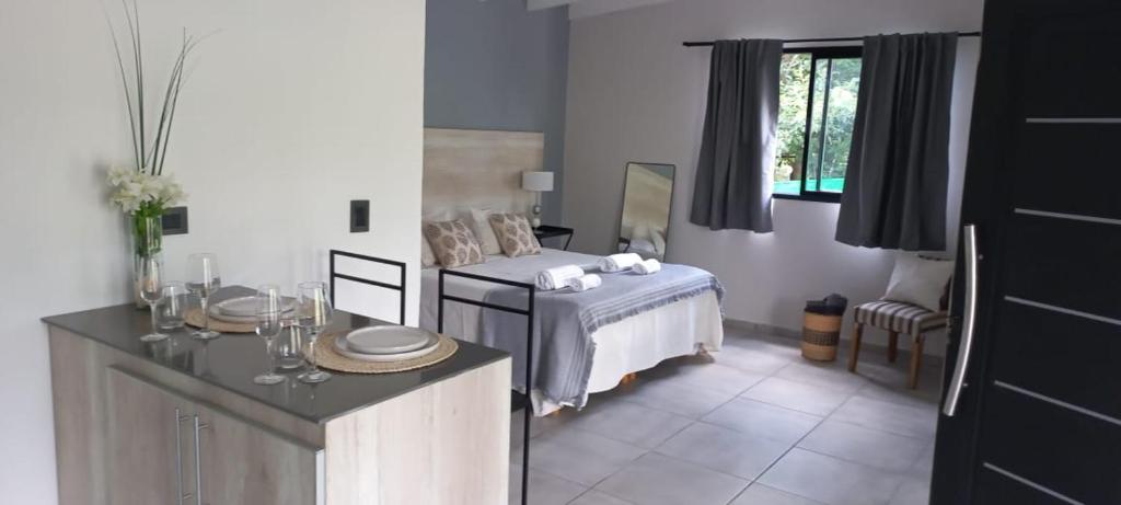 Schlafzimmer mit einem Bett, einem Tisch und einem Fenster in der Unterkunft cabañas La Amelia Premium con piscina privada 2 personas in Mina Clavero