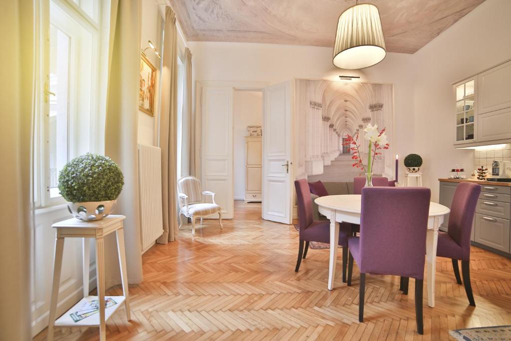 a kitchen and dining room with a table and purple chairs at Nadi's Home – Heart of Budapest in Budapest