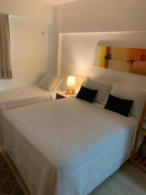 una camera con due letti e una lampada su un tavolo di Apartamento no Beach Place 4 andar da varanda vê o MAR a Cumbuco