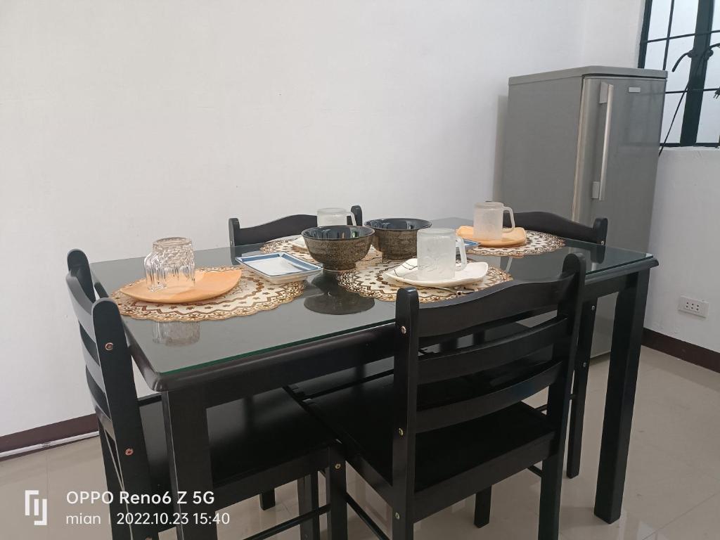 un tavolo nero con sedie, ciotole e piatti di Ethan's lodge a Mangangpico