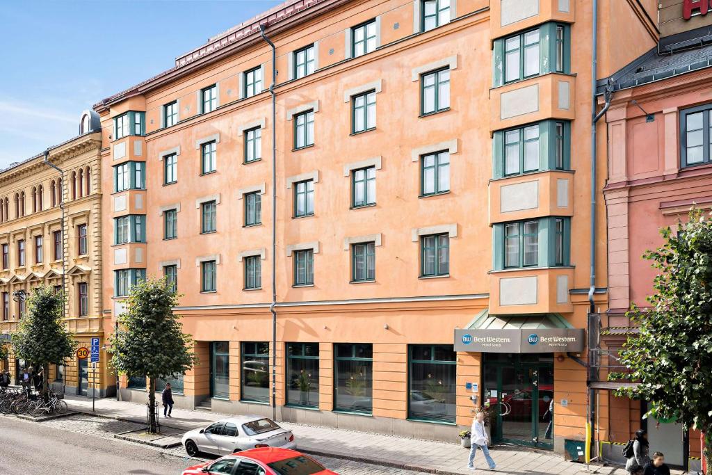 a large orange building on a city street at Best Western Hotel Svava in Uppsala