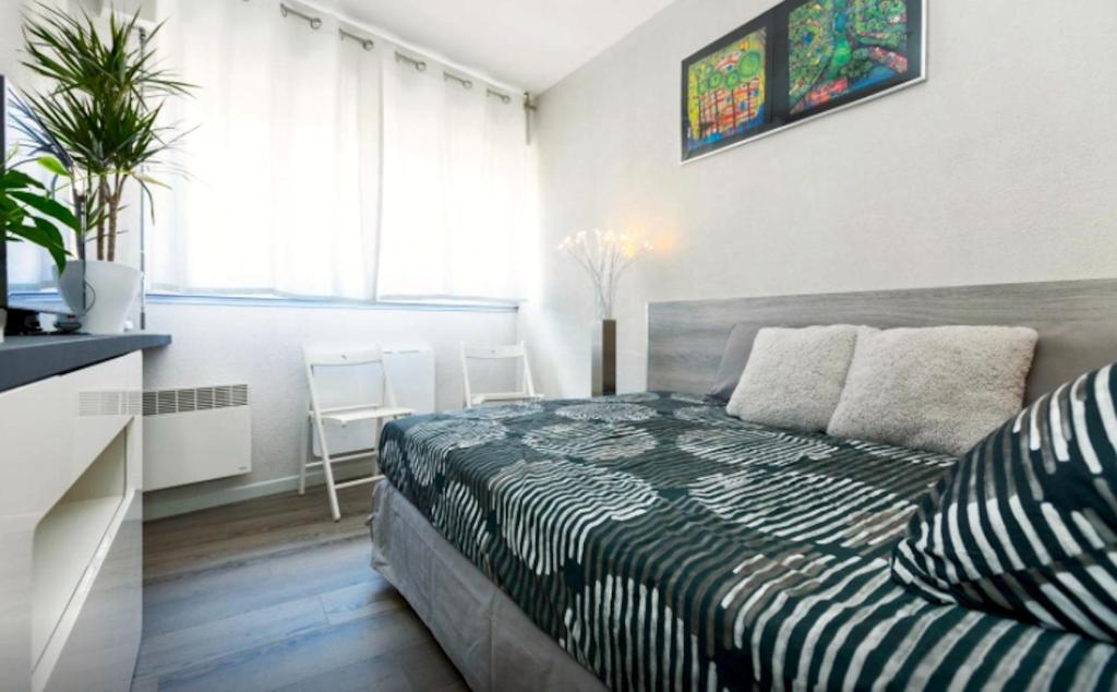a bedroom with a bed and a table and a window at Studio Vue Palais des Papes in Avignon