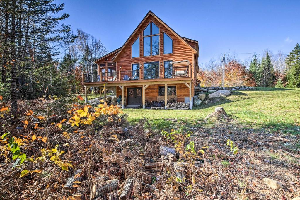 uma casa de madeira numa colina com um quintal em Cozy and Peaceful Waterfront Cabin on Porter Lake! 