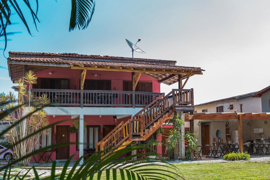 Suítes Las Flores Maresias في ماريسياز: منزل على السطح به سطح وطاحونة هواء