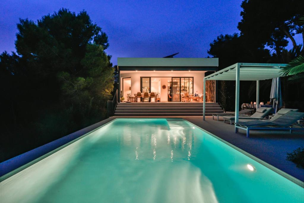 a swimming pool in front of a house at night at Buenavista by Almarina Villas in Benissa