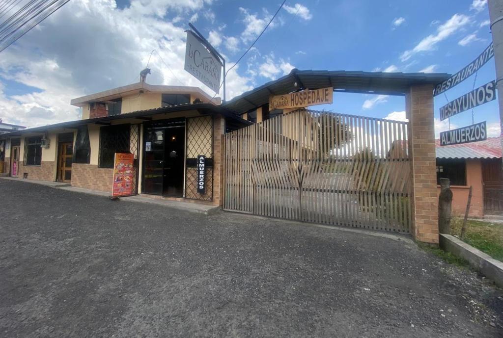 a building with a fence in front of it at Hostería La Cabaña in Machachi