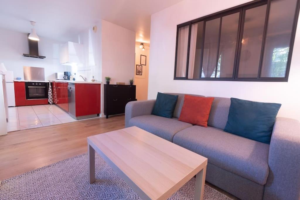 a living room with a couch and a table at Le Cocon-T2-40m2-Centre ville 10min Disney in Bussy-Saint-Georges