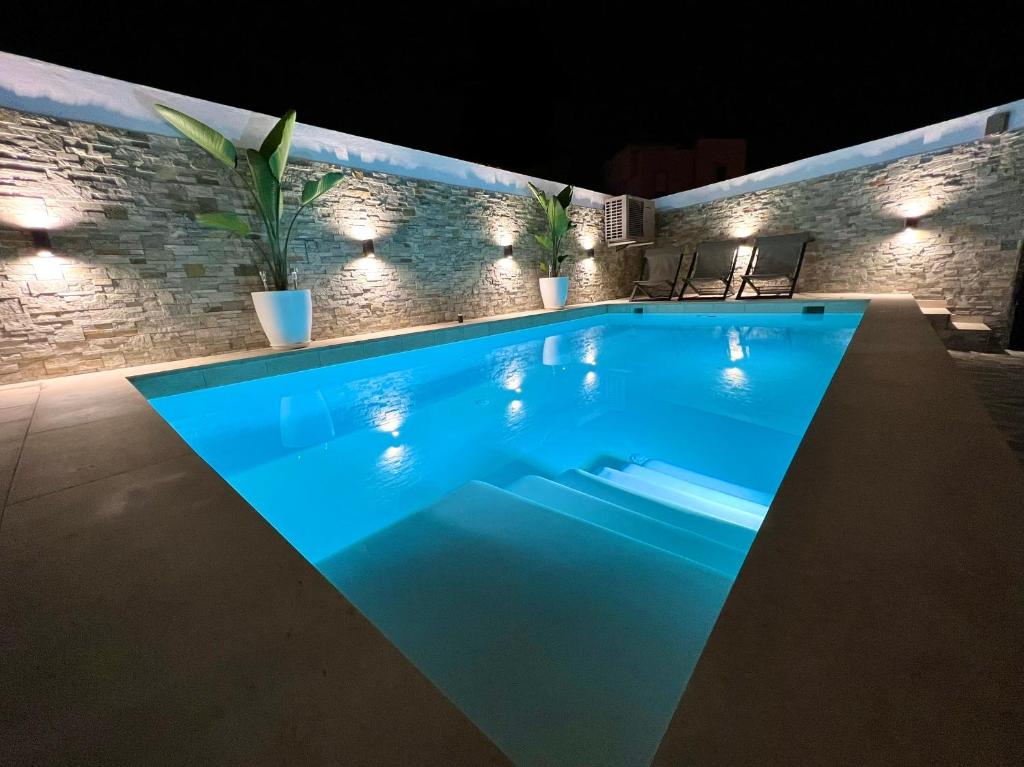 Luxury house Atlantico private heated pool في أديخي: اضاءة المسبح ليلا