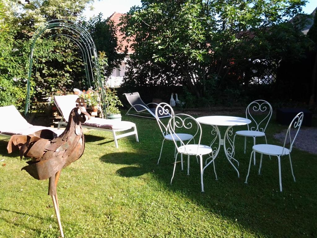 a statue of a turkey standing next to a table and chairs at Les 3 Clés in Dossenheim-Kochersberg