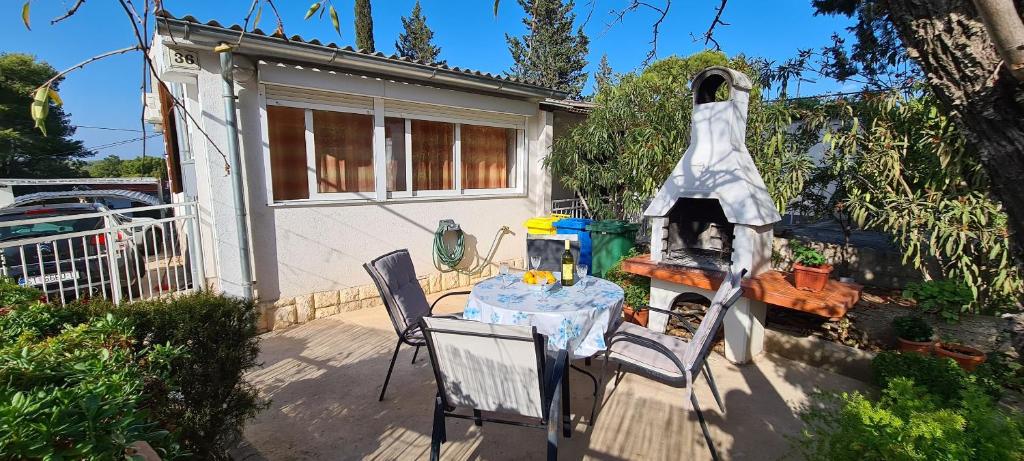 um pátio com uma mesa e cadeiras em frente a uma casa em Apartment Close to the beach em Stari Grad