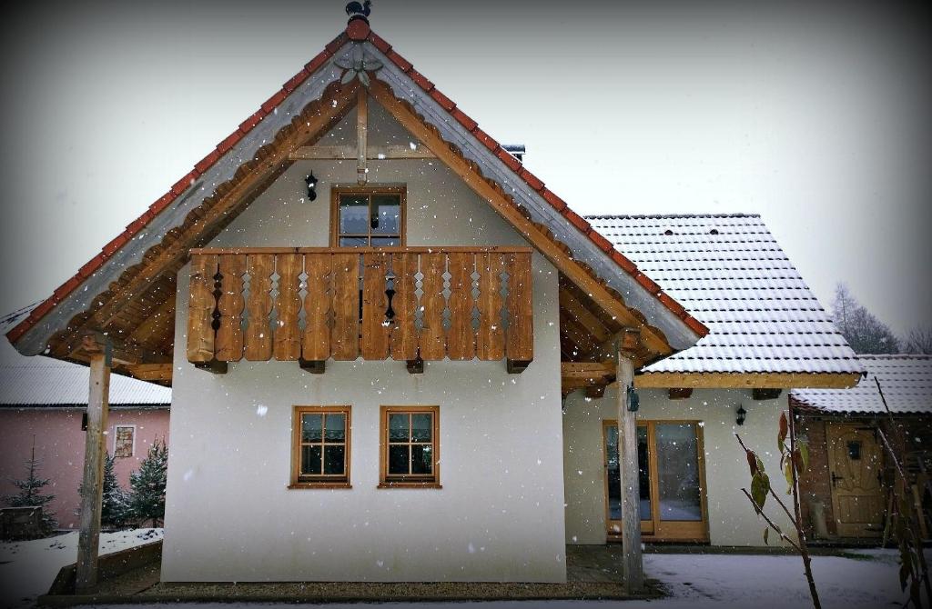 ein schneebedecktes Haus mit einem Holzdach in der Unterkunft Chalupka na Orave in Dolný Kubín