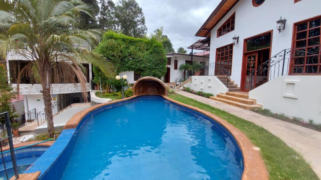 a swimming pool in front of a house at El Castillo de Nallig in Gualaceo