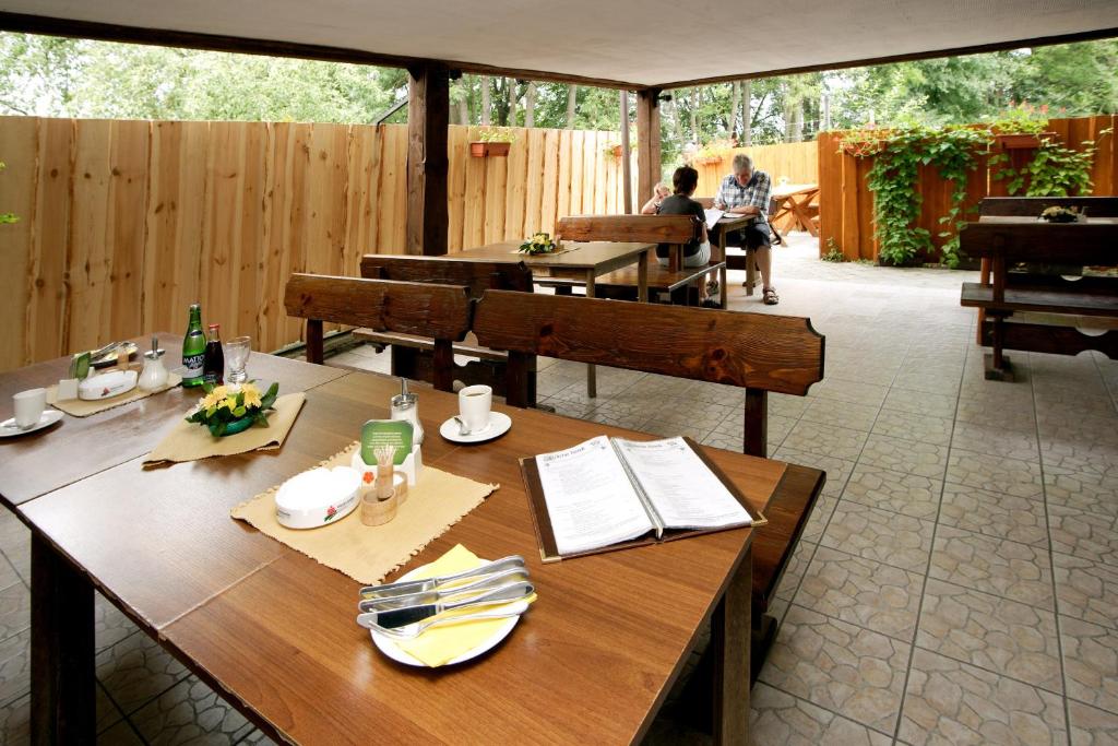 a patio with wooden tables and people sitting at tables at Rodinný hotel Myslivna in Třeboň