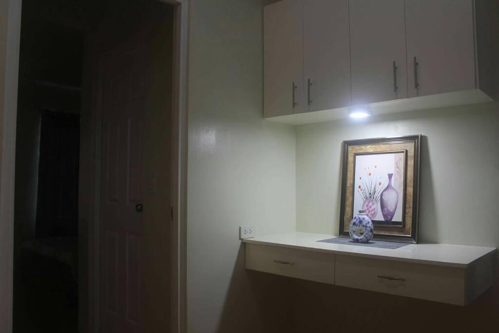 una cocina blanca con una foto en un estante en Pontefino Prime Townhouse 4BR with Wifi & Pool, en Batangas