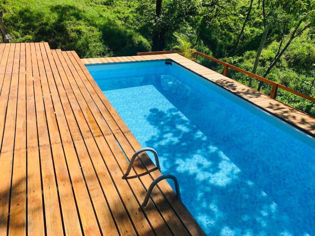 a swimming pool on a wooden deck with a swimming pool at Cabañas del Bosque in Nandayure