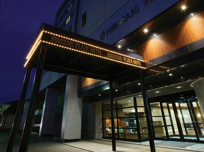 budynek z oświetlonym znakiem przed nim w obiekcie Hirosaki Plaza Hotel w mieście Hirosaki