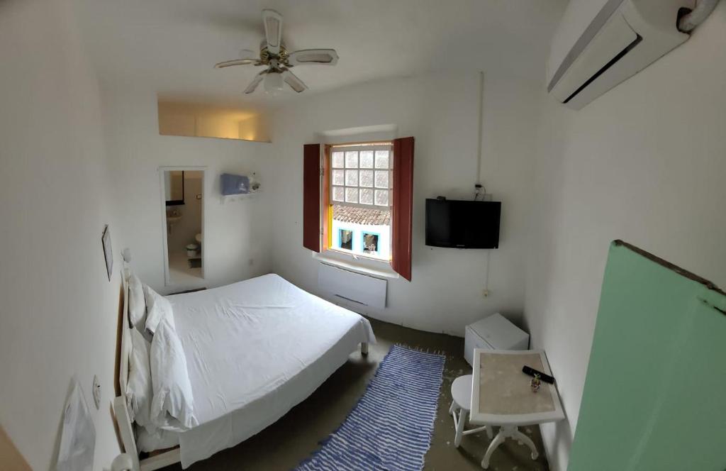 - une chambre blanche avec un lit et une fenêtre dans l'établissement Pousada Casa Da Lapa, à Parati