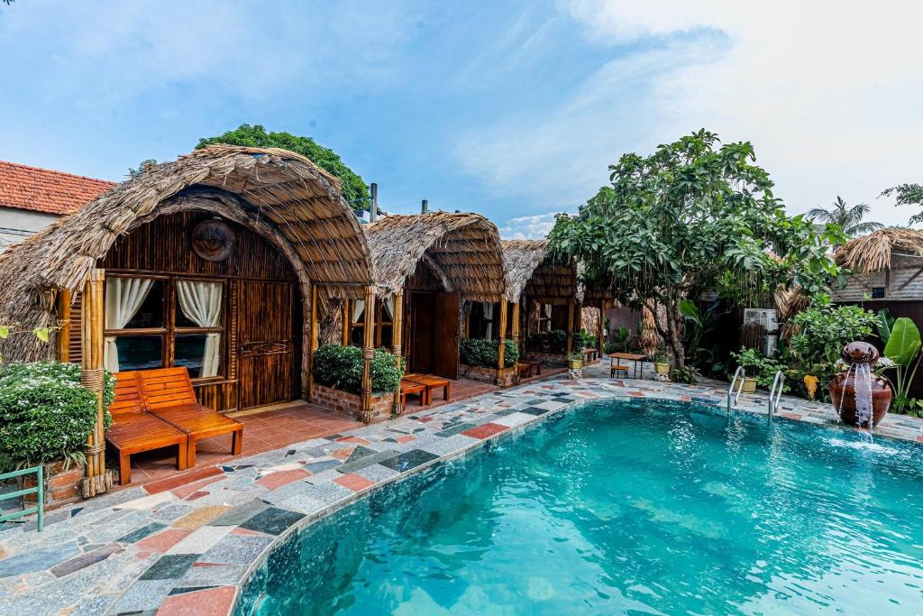 um resort com piscina em frente a uma casa em Tam Coc Bungalow em Ninh Binh