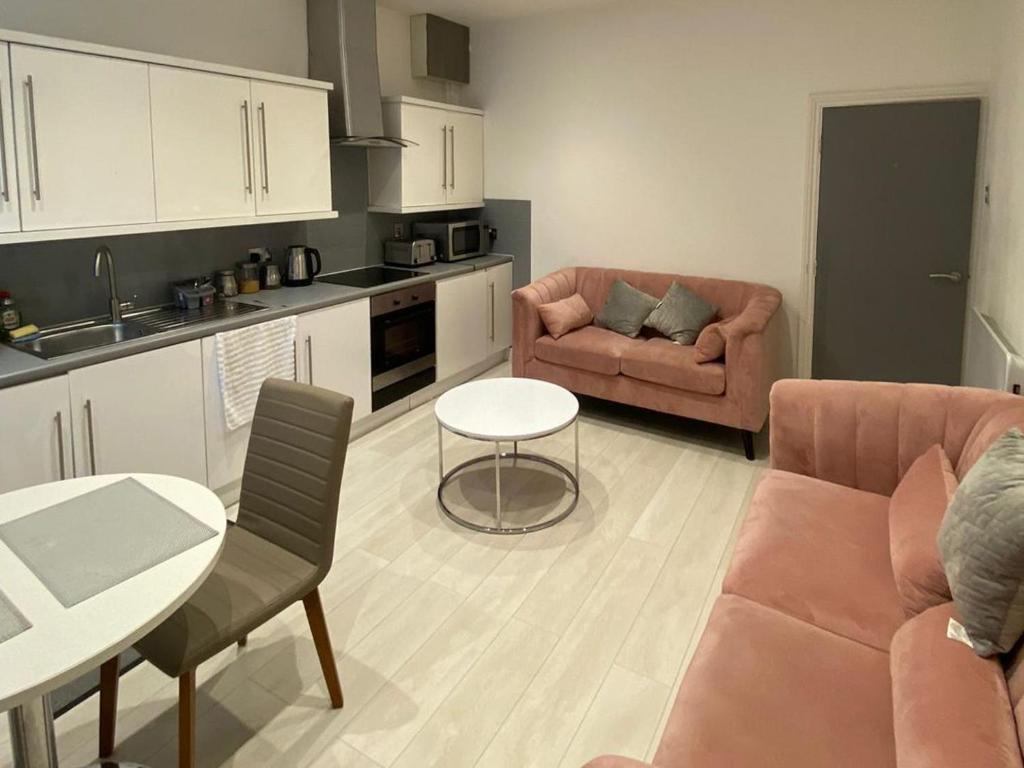 a kitchen and living room with a couch and a table at New York Apartment in Heeley