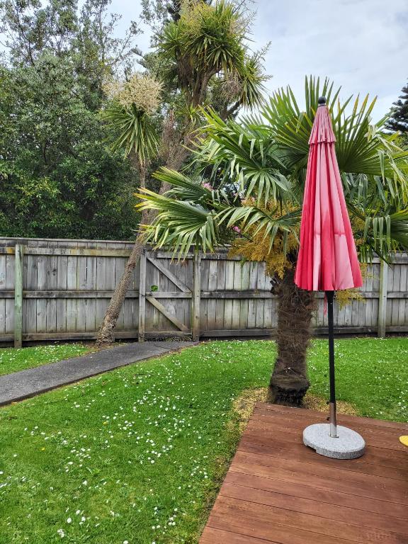 a red umbrella sitting on top of a yard at The perfect getaway for two in a large suite in Whanganui