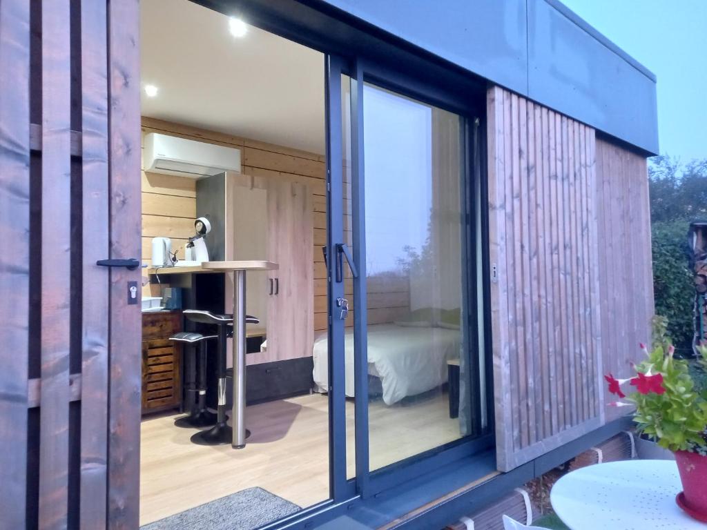 a room with a sliding glass door leading to a bedroom at "Plus belle l'Ardèche" Studio de jardin et piscine in Vinezac