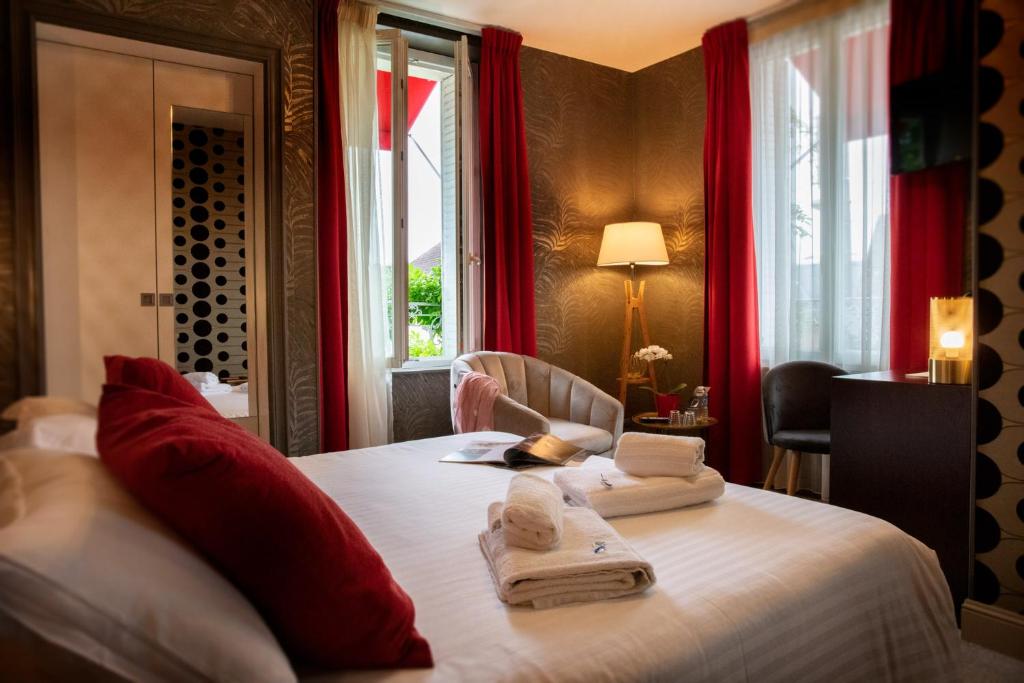 Una habitación de hotel con una cama con toallas y una ventana en Logis Hôtel Restaurant La Breche en Amboise