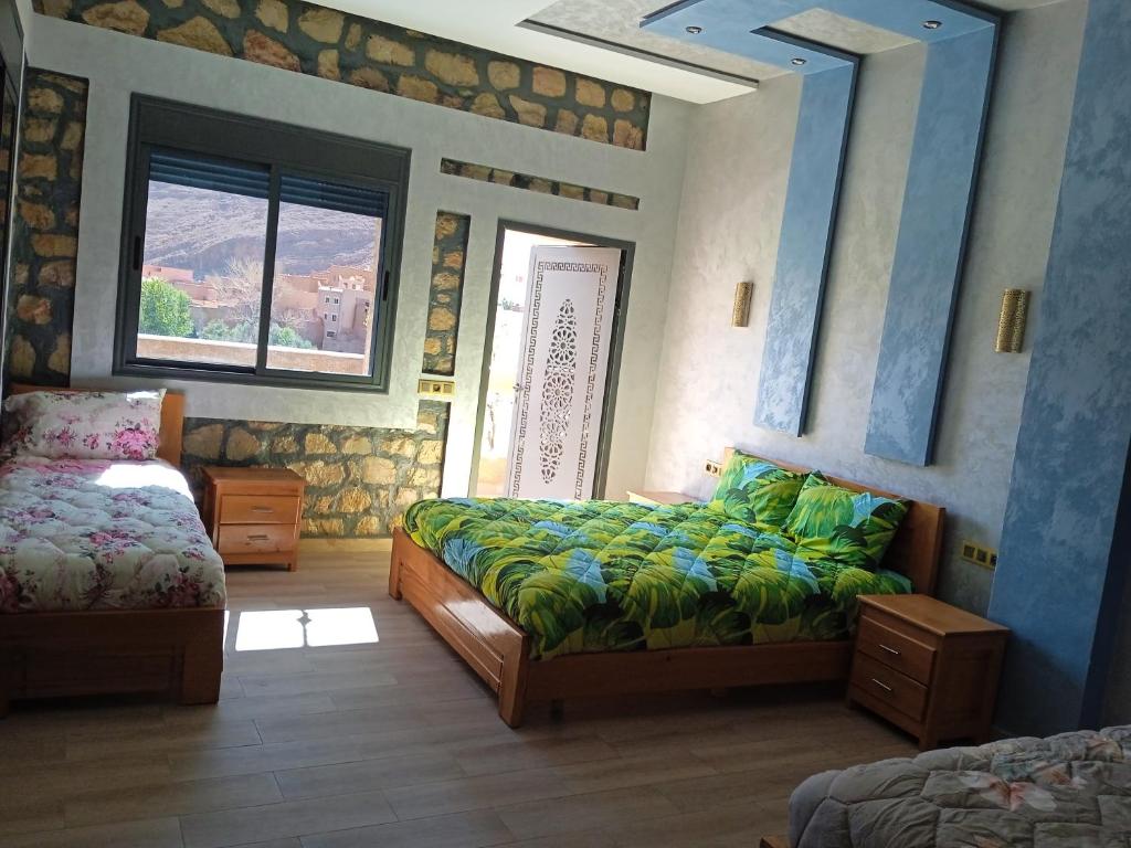 um quarto com uma cama e uma janela em Relais Des Nomades em Tinghir